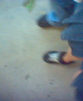 the legs of a pair of people in slippers on a sidewalk