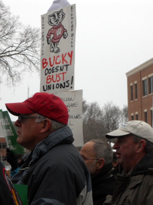 some people standing in front of a sign that says bucky doesn't bust unions