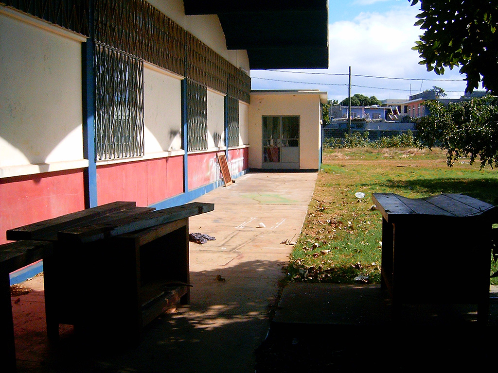 a bench and trash cans line the front of a building