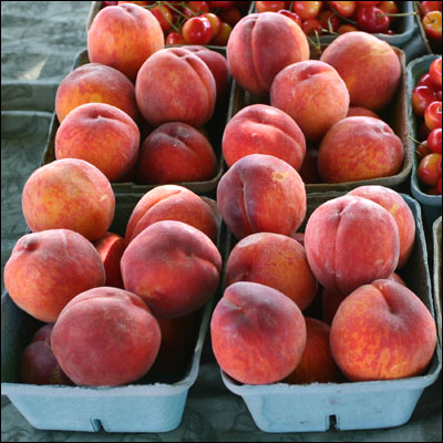 a display of many boxes filled with peaches