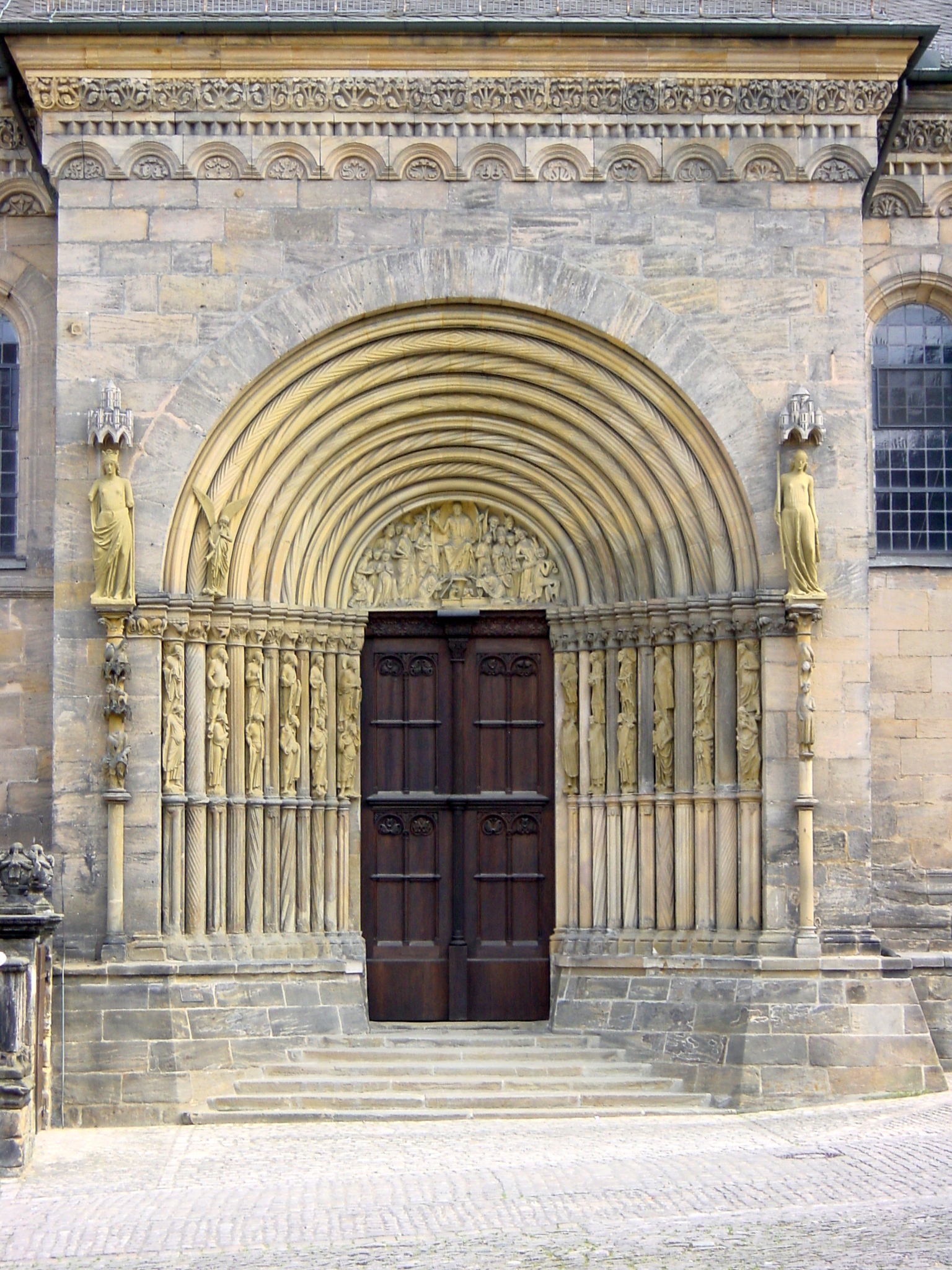 an arched doorway with carvings in the stone wall