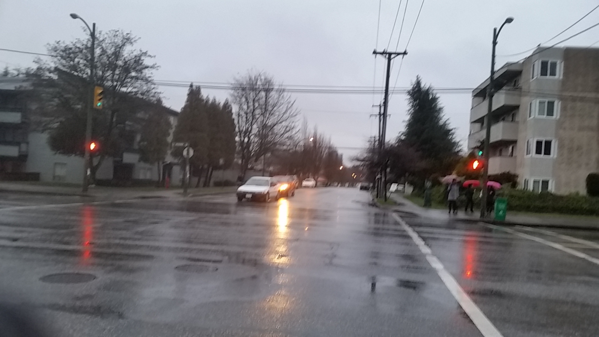 a city street is wet and cloudy with lights