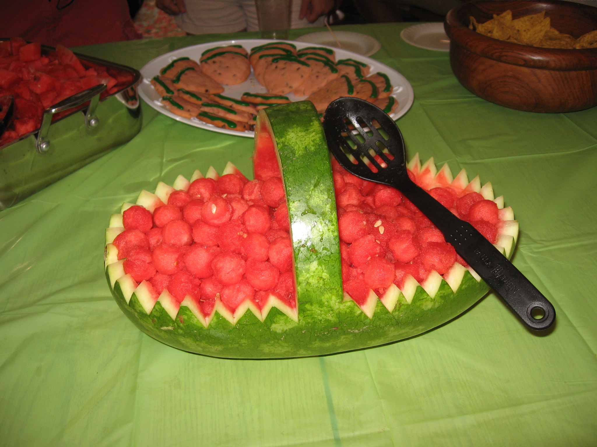 watermelon carved into a fish scale with cookie shaped cookies and dippers