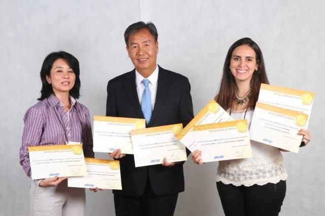 a couple of women holding up papers while standing next to a man