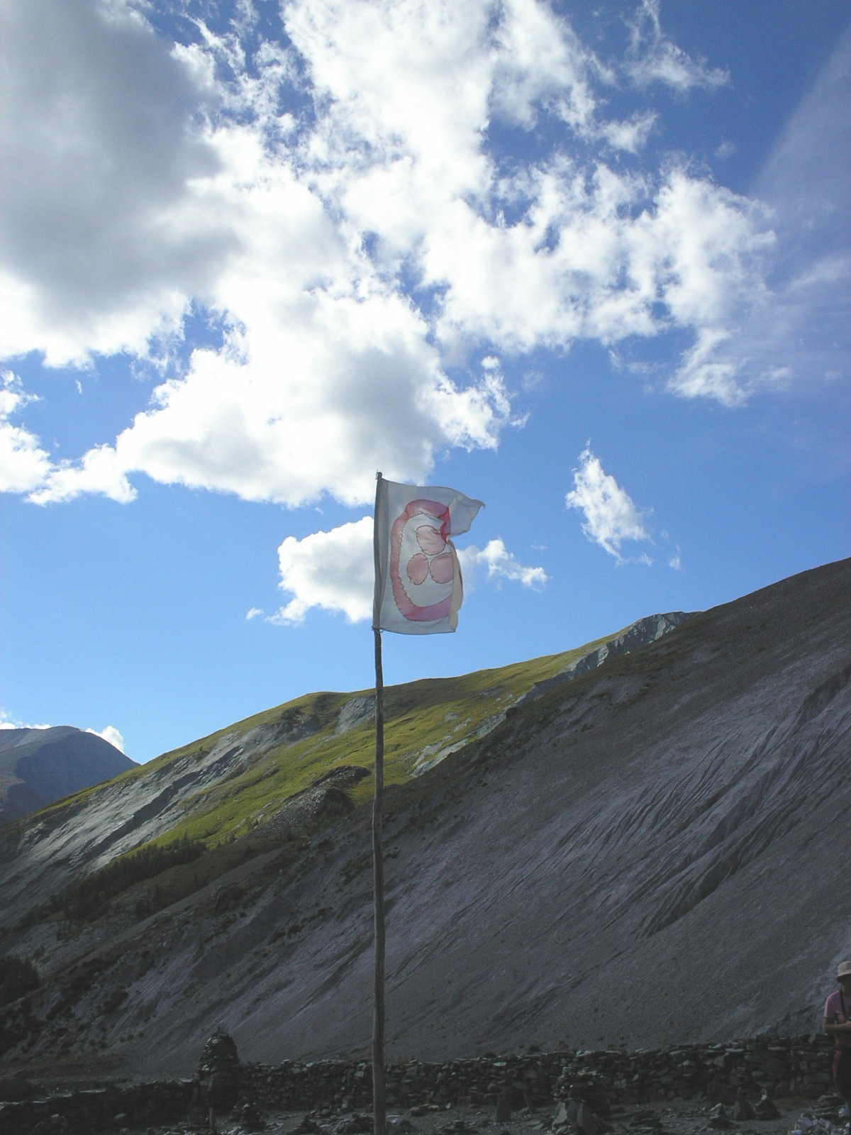 a picture of the back side of a mountain and a flag on top of a pole