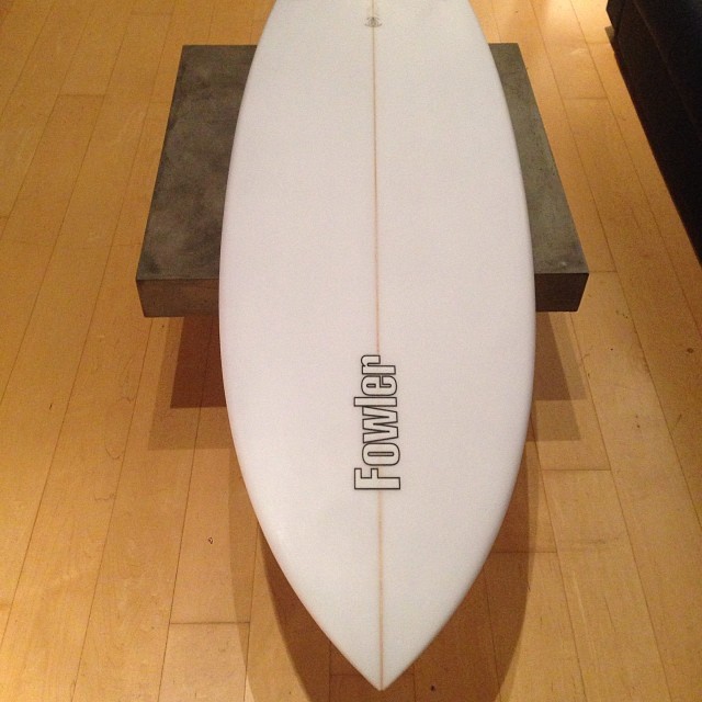 the top view of a surfboard and bench on wooden floor
