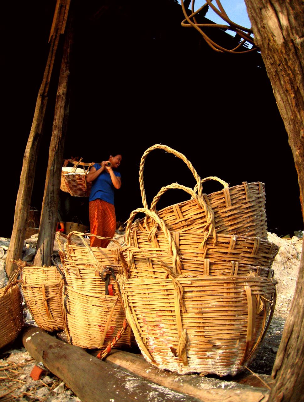 baskets piled on top of each other near a woman