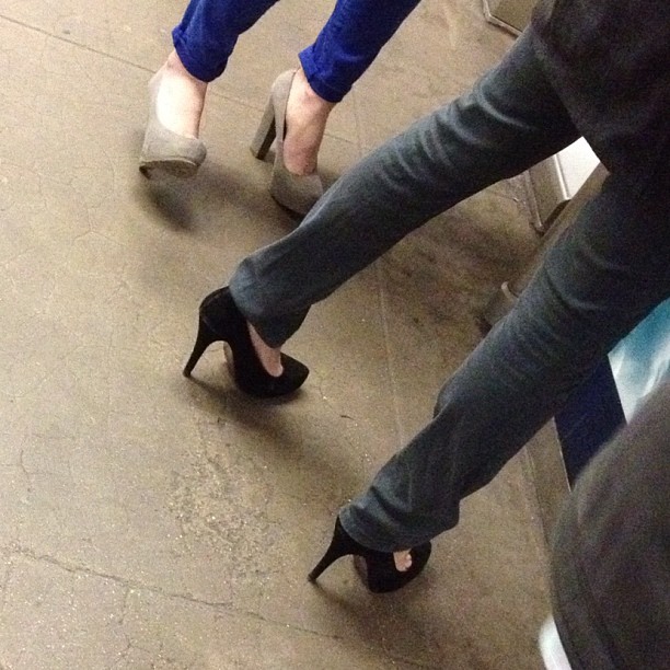 the lower view of two womans legs and high heels