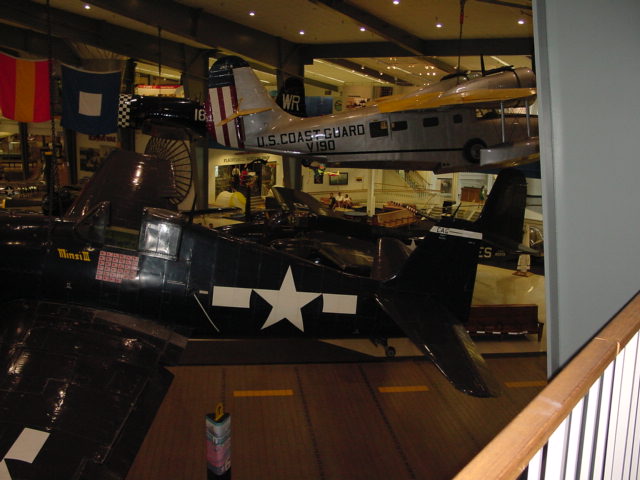museum display featuring planes, flags and other memorabilia