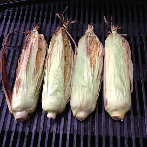four pieces of corn sitting on a grill