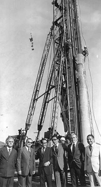 the men are standing outside by a tower