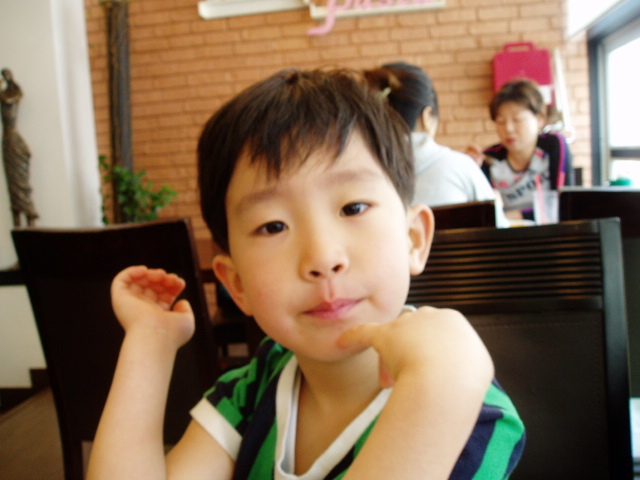 a young child posing for the camera at a restaurant