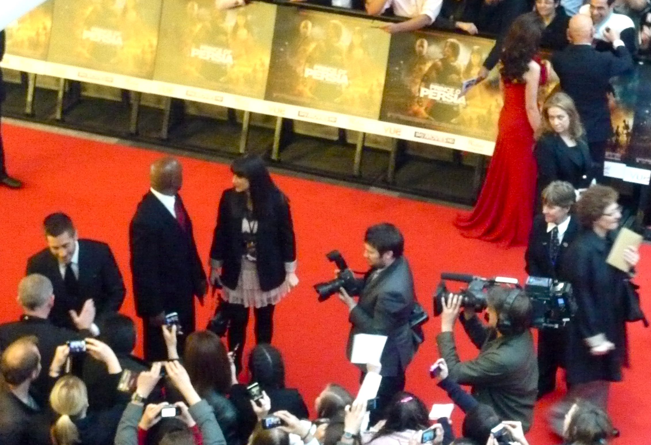 a man is surrounded by reporters on red carpet