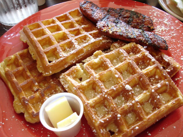 a red plate topped with waffles, er and syrup