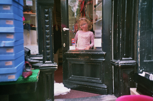 girl looking out of window in doorway of store