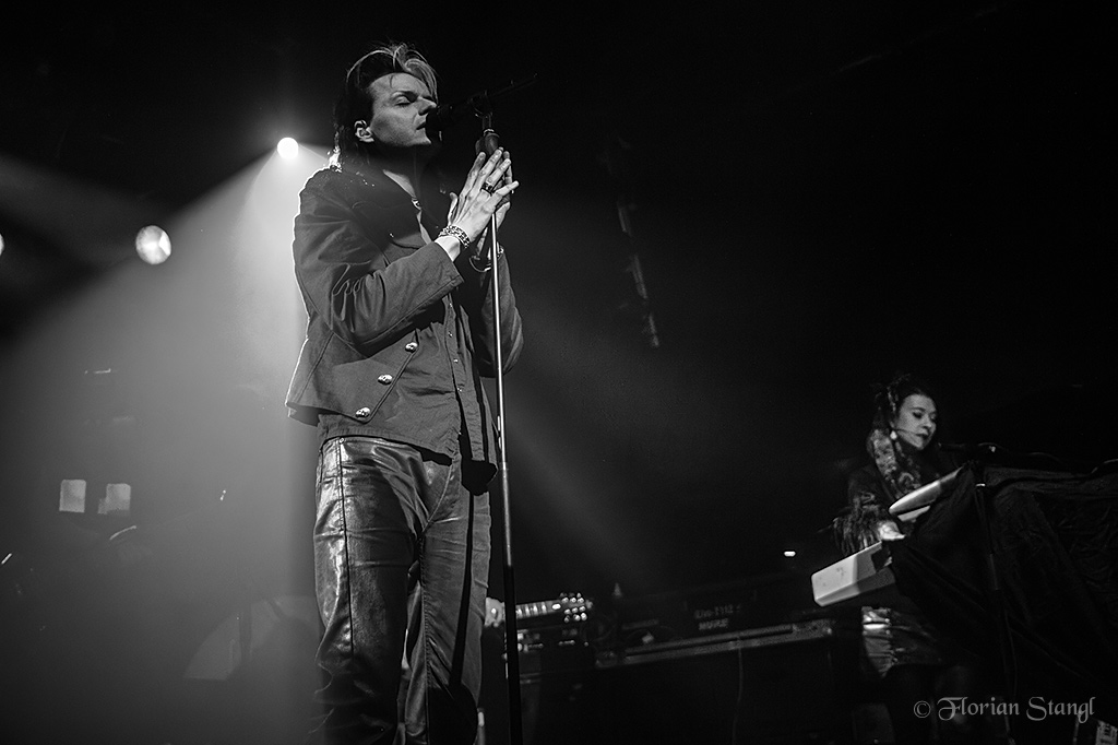 a black and white po of a man standing in front of a microphone