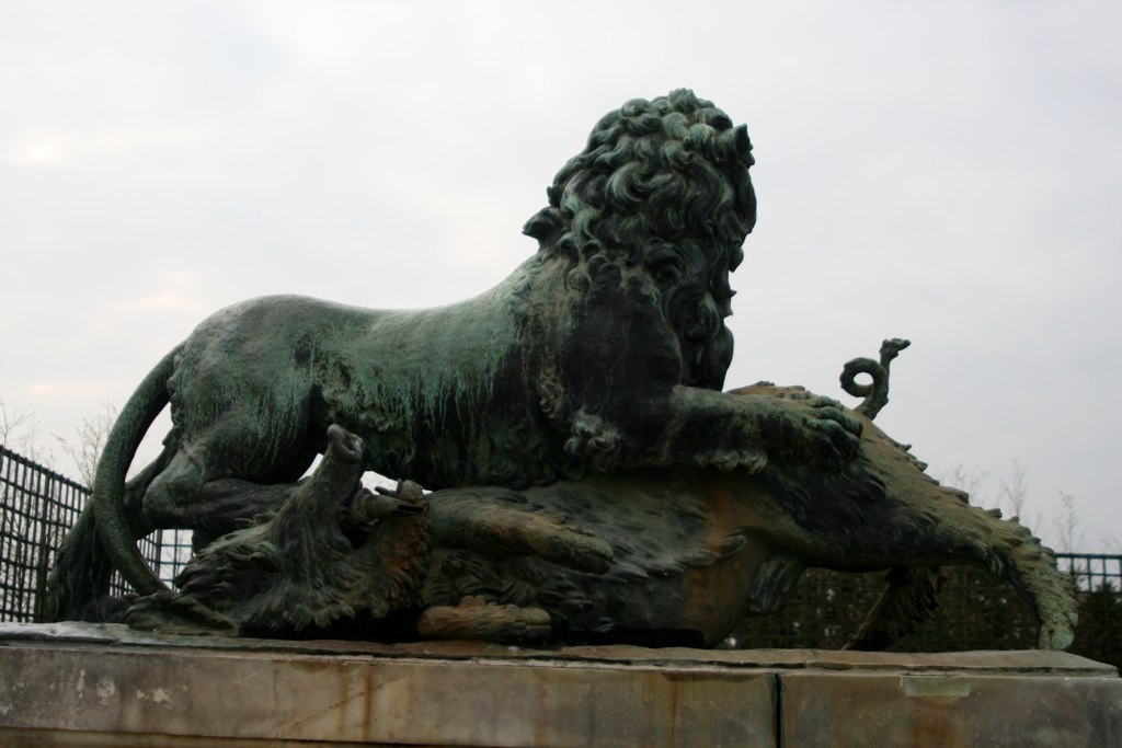 this statue has a lion laying on it