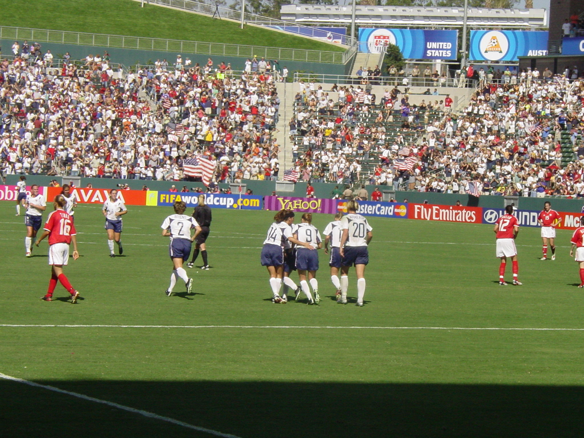 teams of soccer players standing in the middle of a field