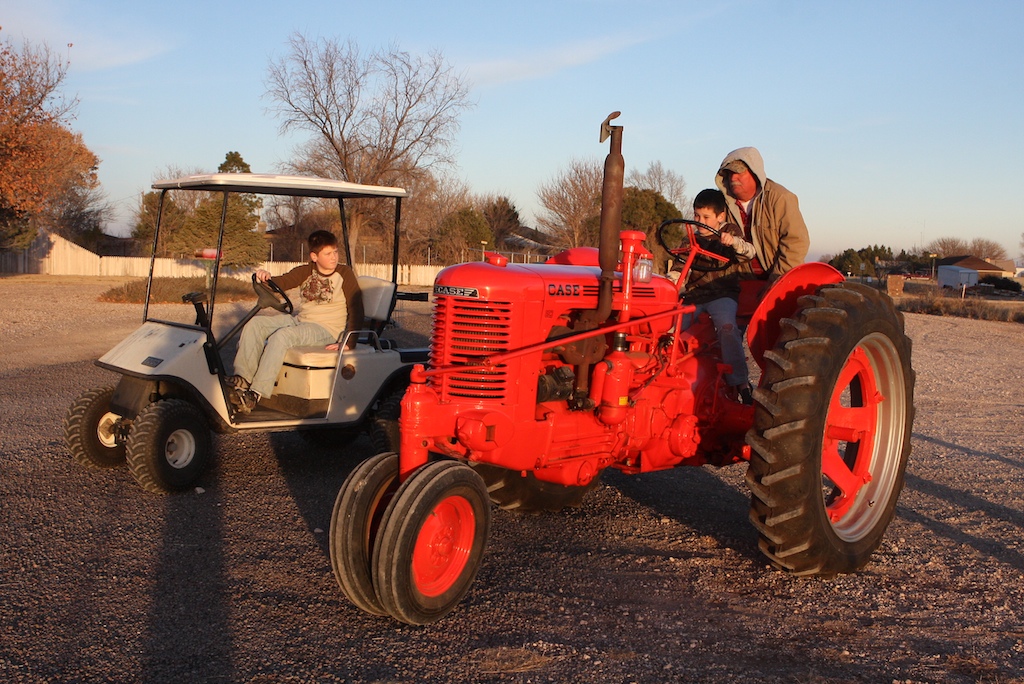 a couple sitting on the back of a vintage tractor