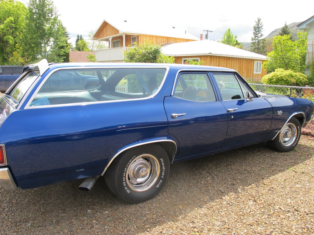 a blue car parked in a driveway next to a building