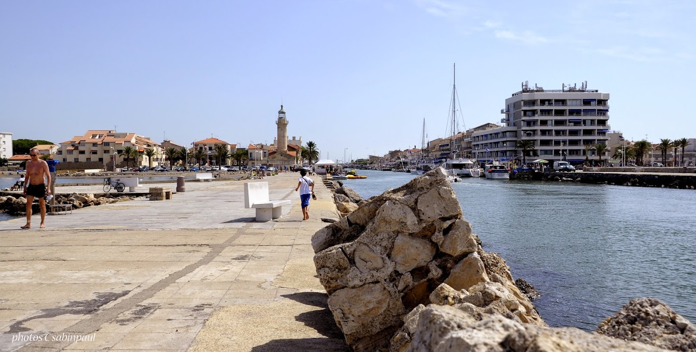 some people walking along the water on a clear day