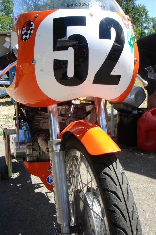 a orange motorcycle with number 52 on it parked