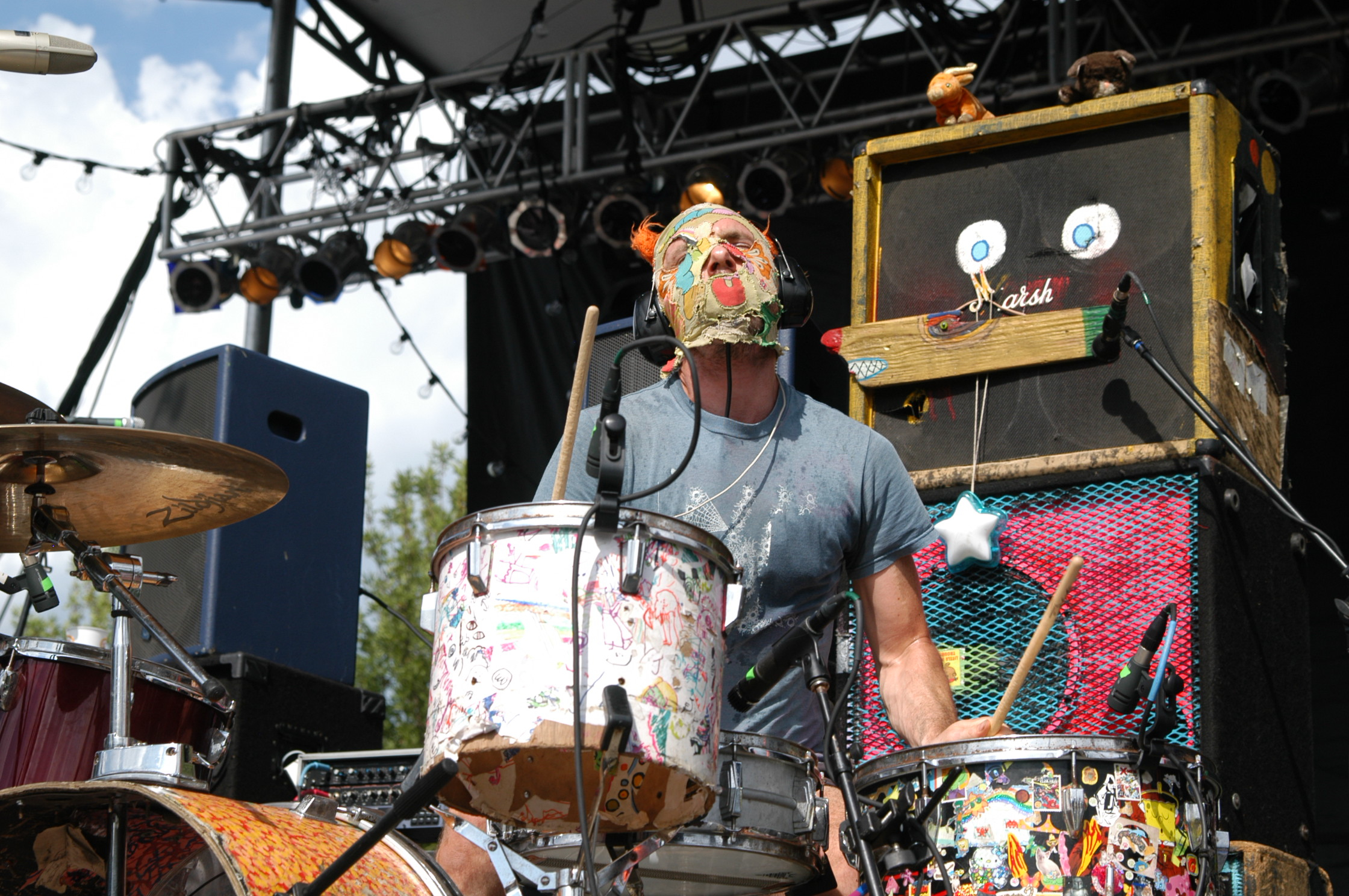 a man standing in front of two drum kit in the sun