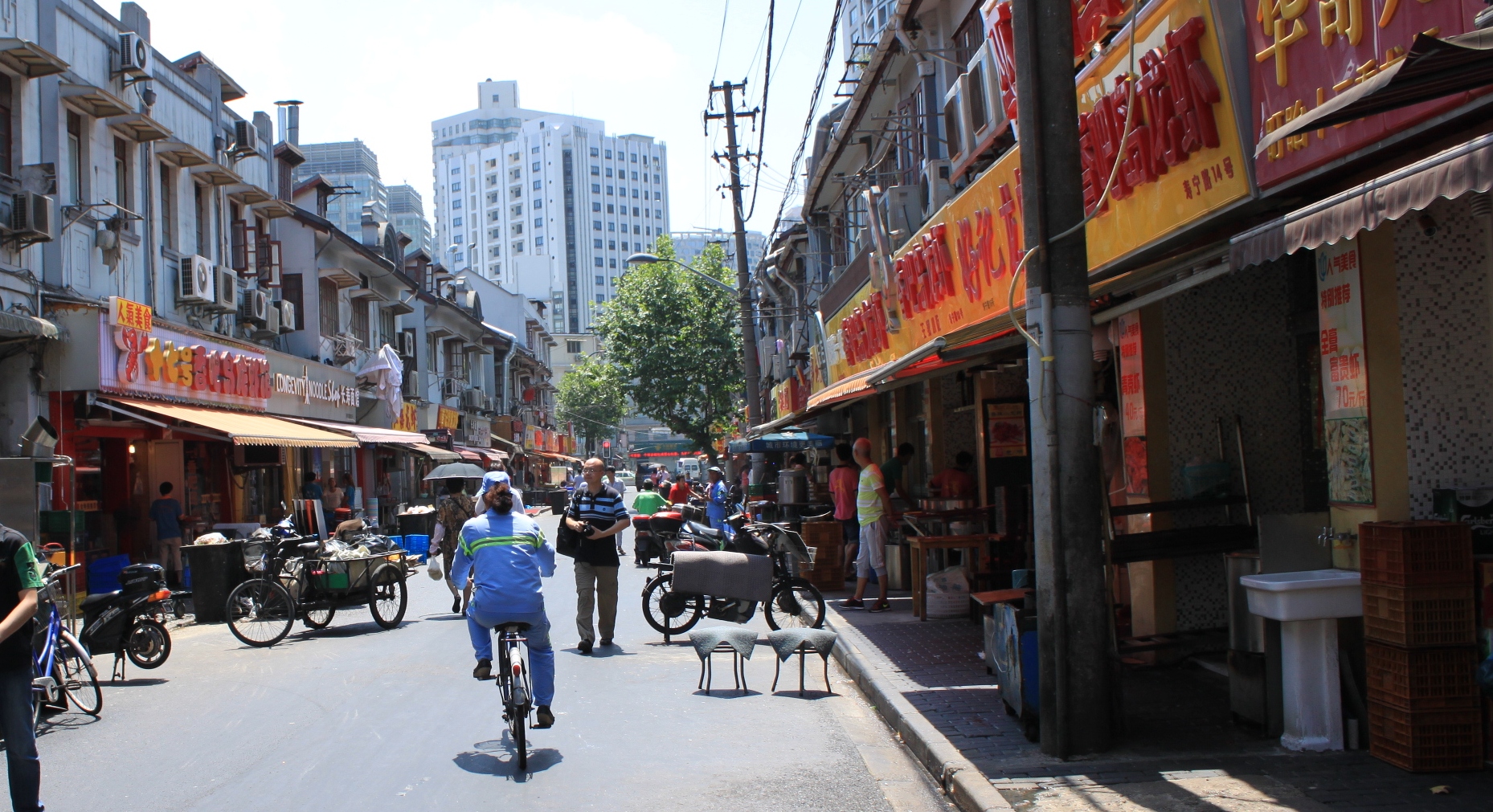 the street with bikes and pedestrians has several people on bikes