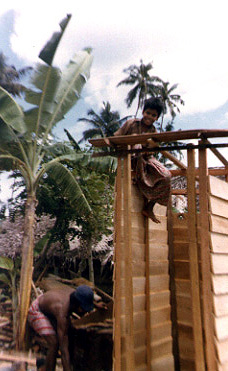 two people working on a wooden structure at a park