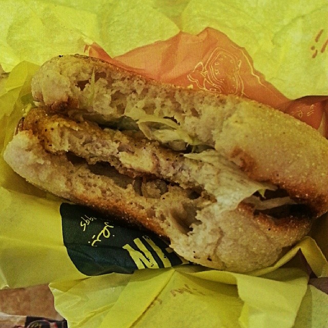 an over - cooked sandwich on a yellow wrapper