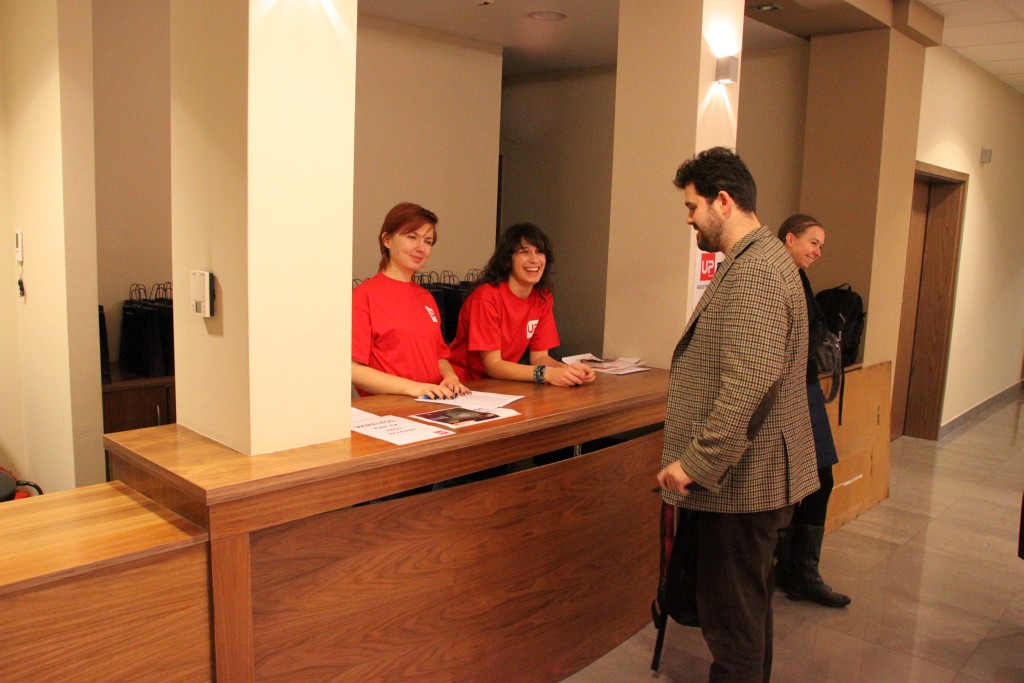 the man stands near the counter as others look on