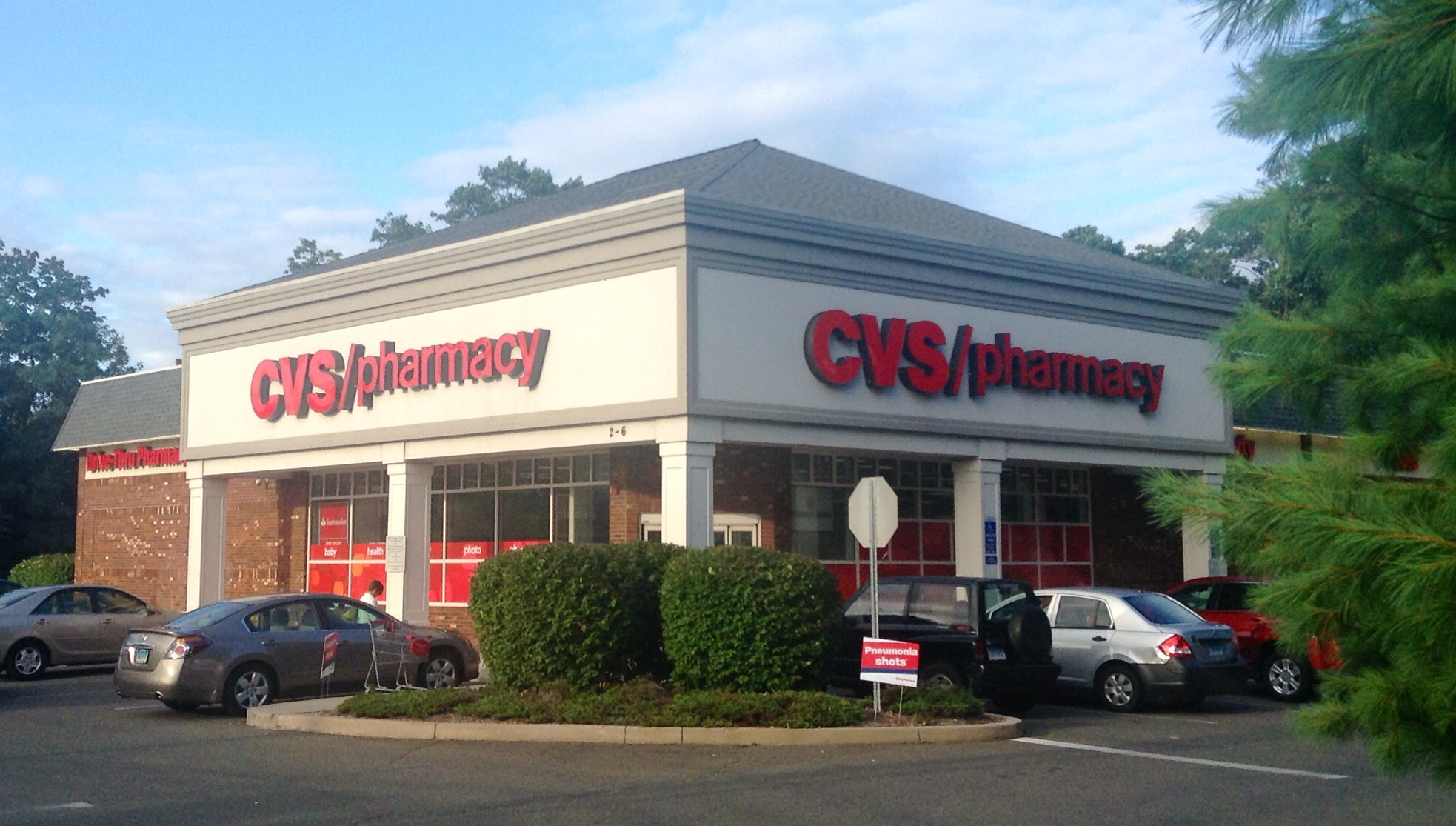 a cvs pharmacy with parked cars and parking lot