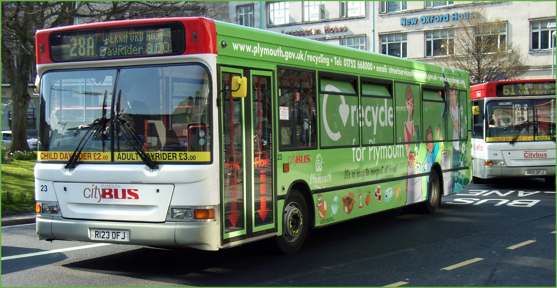 a white and green bus is on a city street