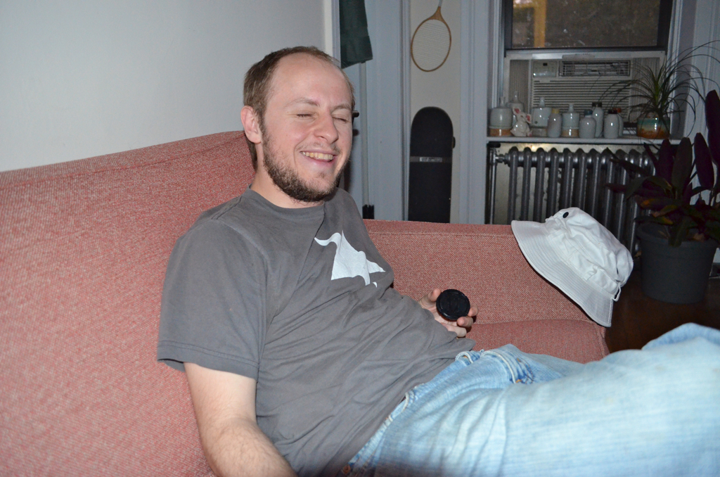 a man smiles as he lies down on a couch
