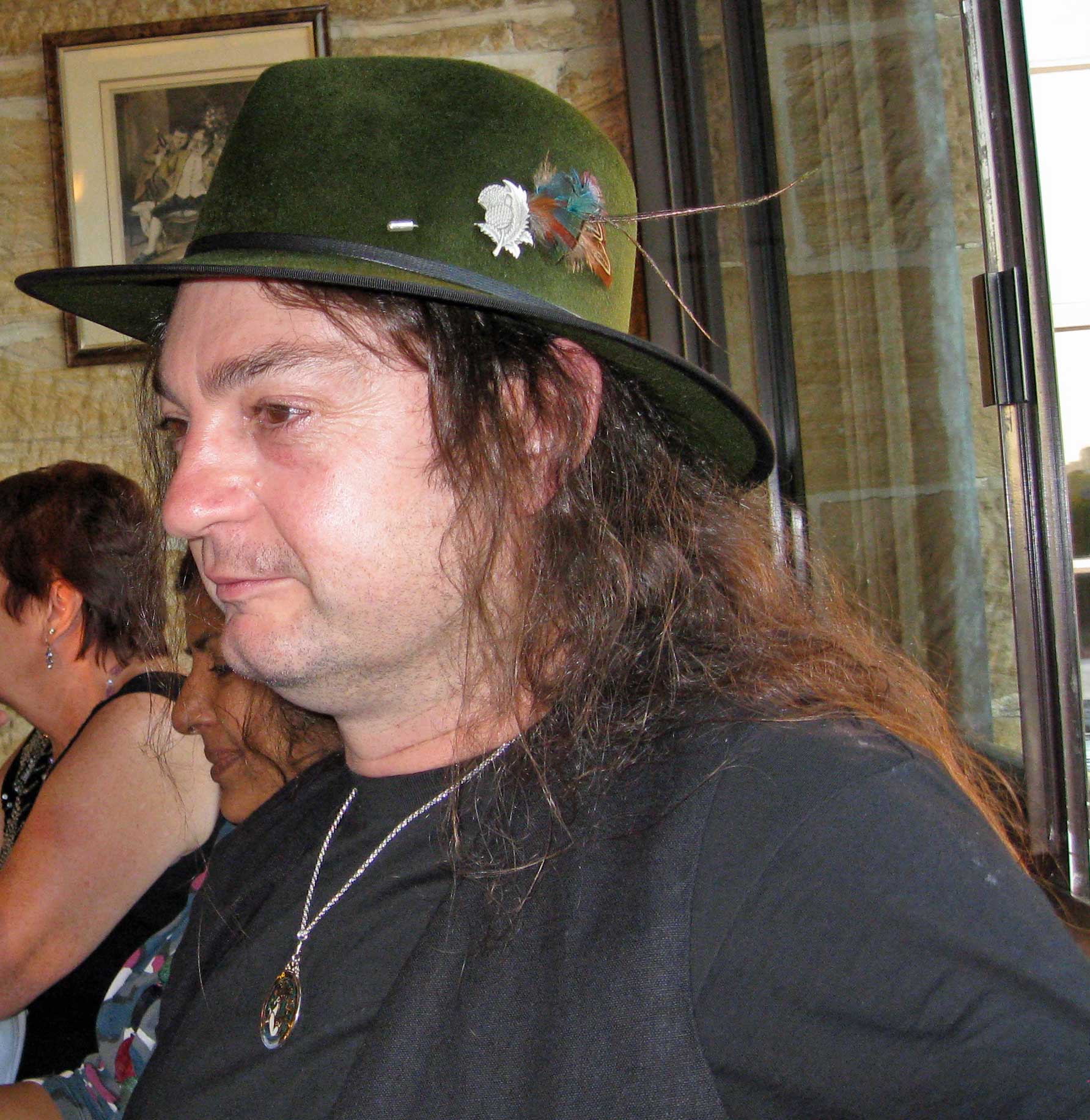 a man in green hat at party in brick wall