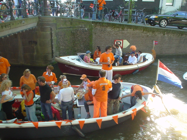 several people on boats at an orange ribbon ceremony