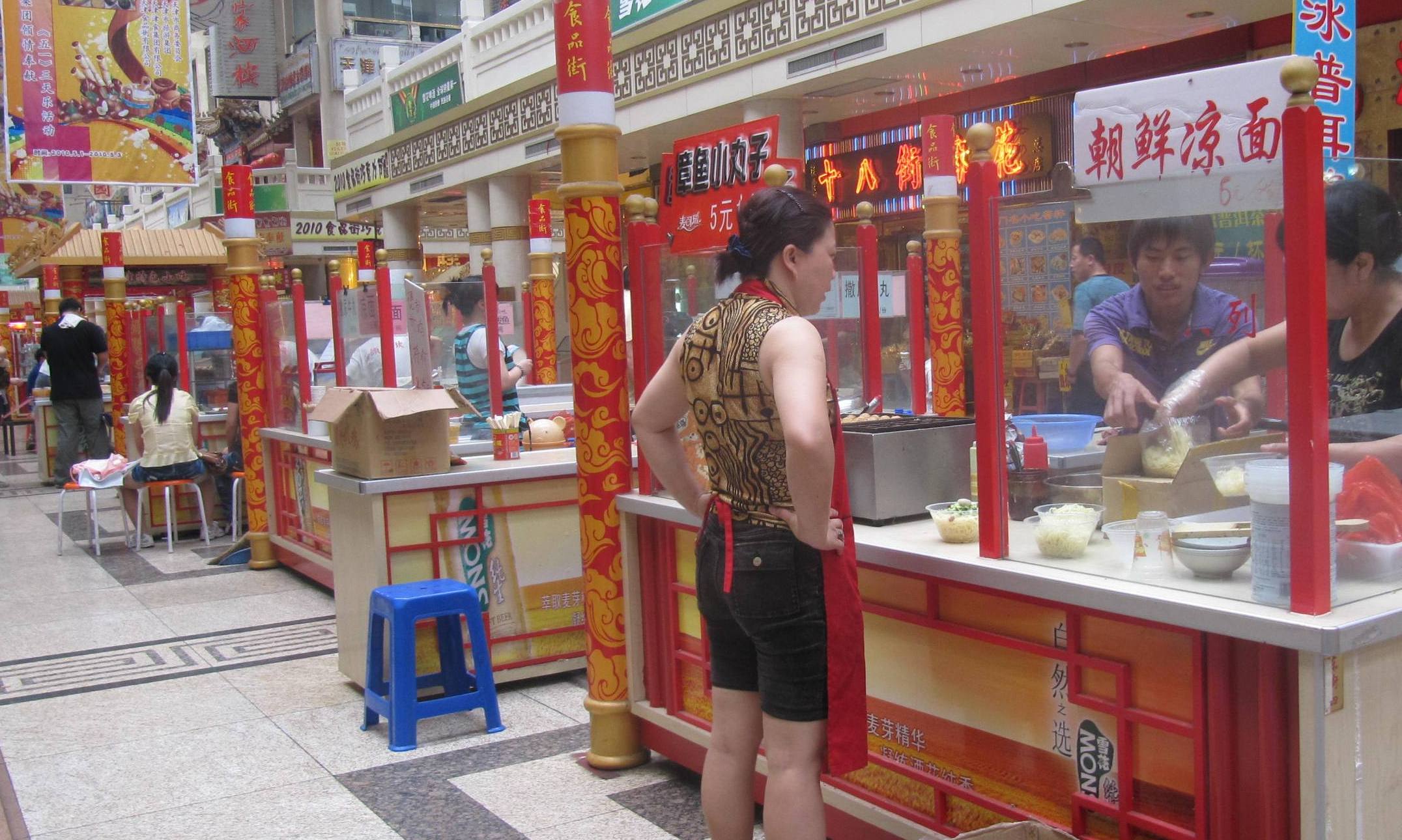two people preparing food in an asian store