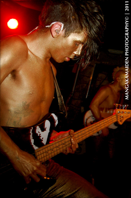 a young man in black shirt playing bass guitar