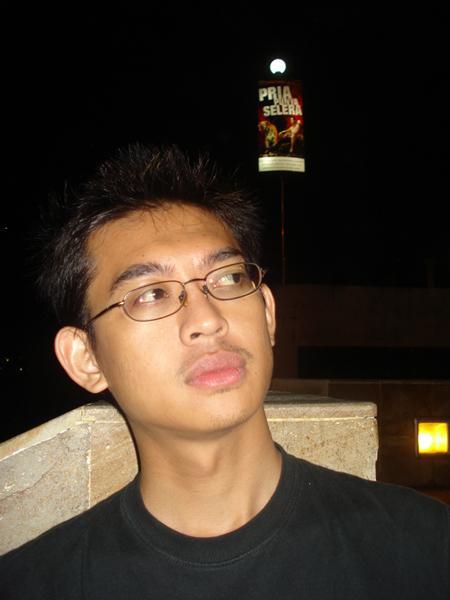 a young man in glasses looks at the camera