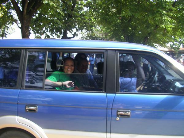 a woman and boy sit in the passenger seat of a car