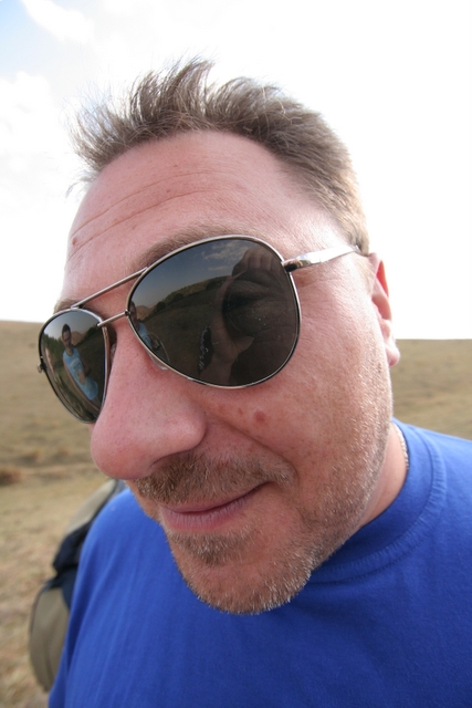 man in sunglasses smiling and looking off camera