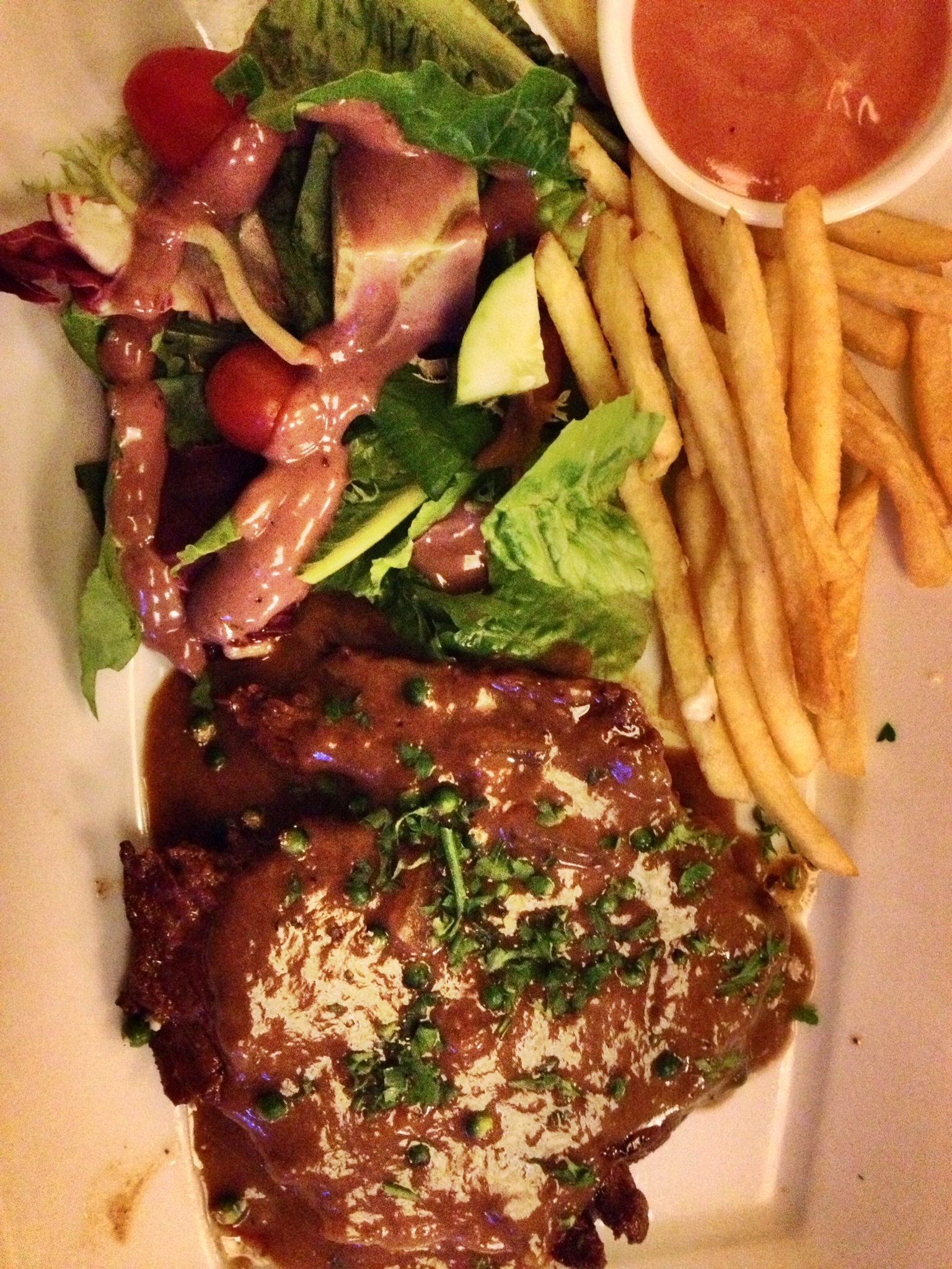 the meal features meat and french fries, salad and dressing