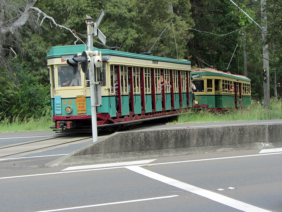 an old trolley car on tracks sitting on the side of the street