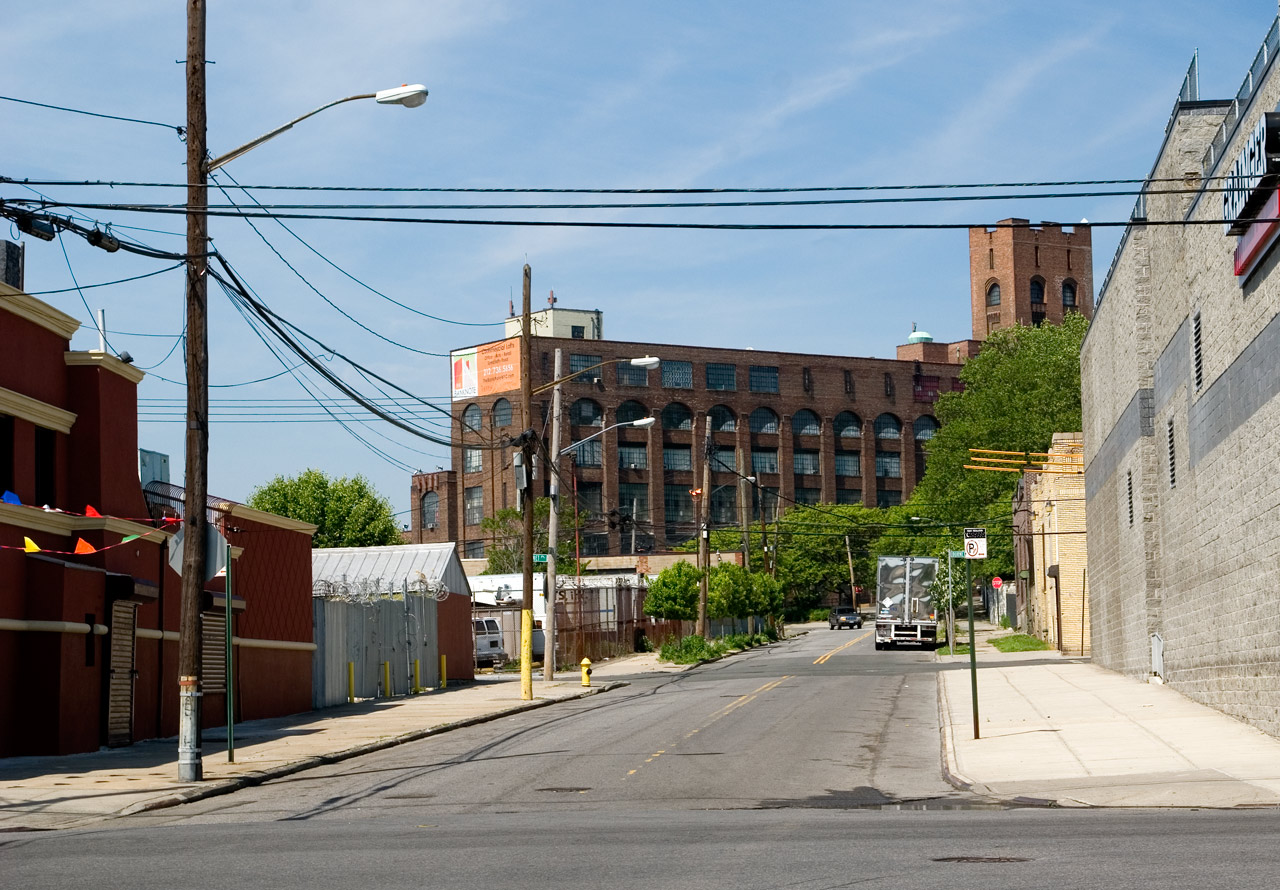 an empty street next to some brick buildings and a stop sign