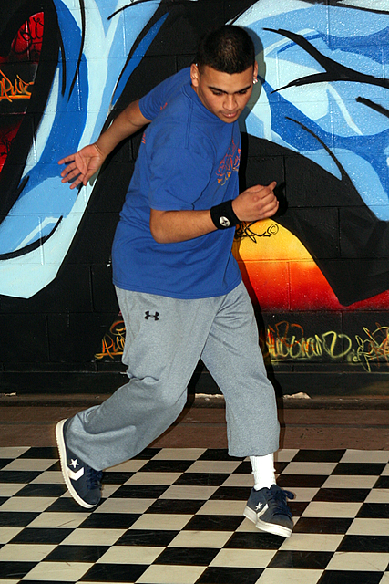 a boy with tennis racket in mid air, walking