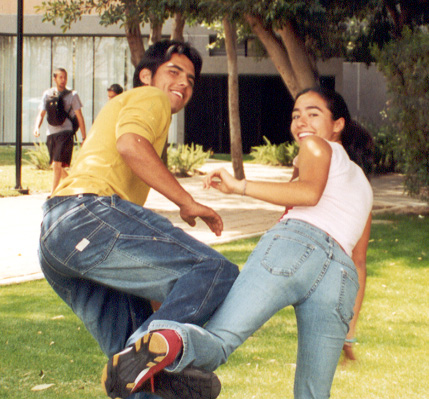 two young people are playing with a frisbee on the grass