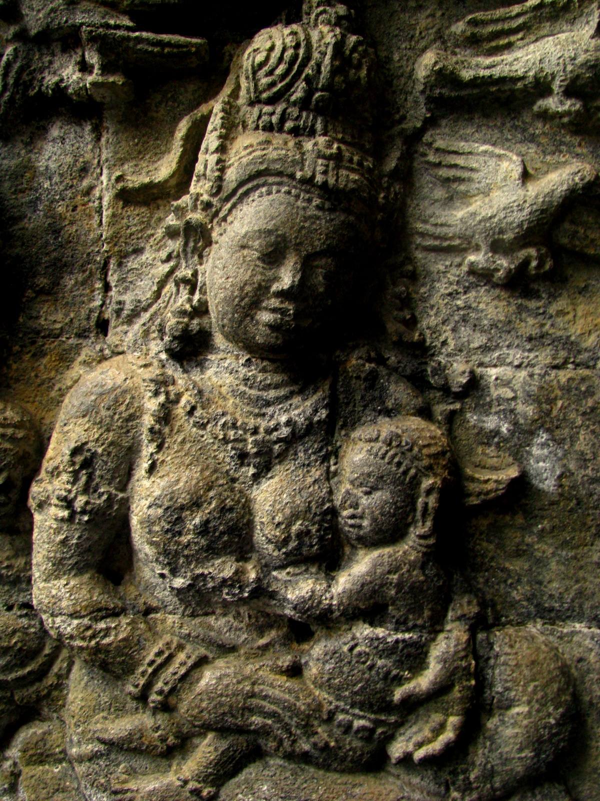 an ancient statue in front of a brick wall