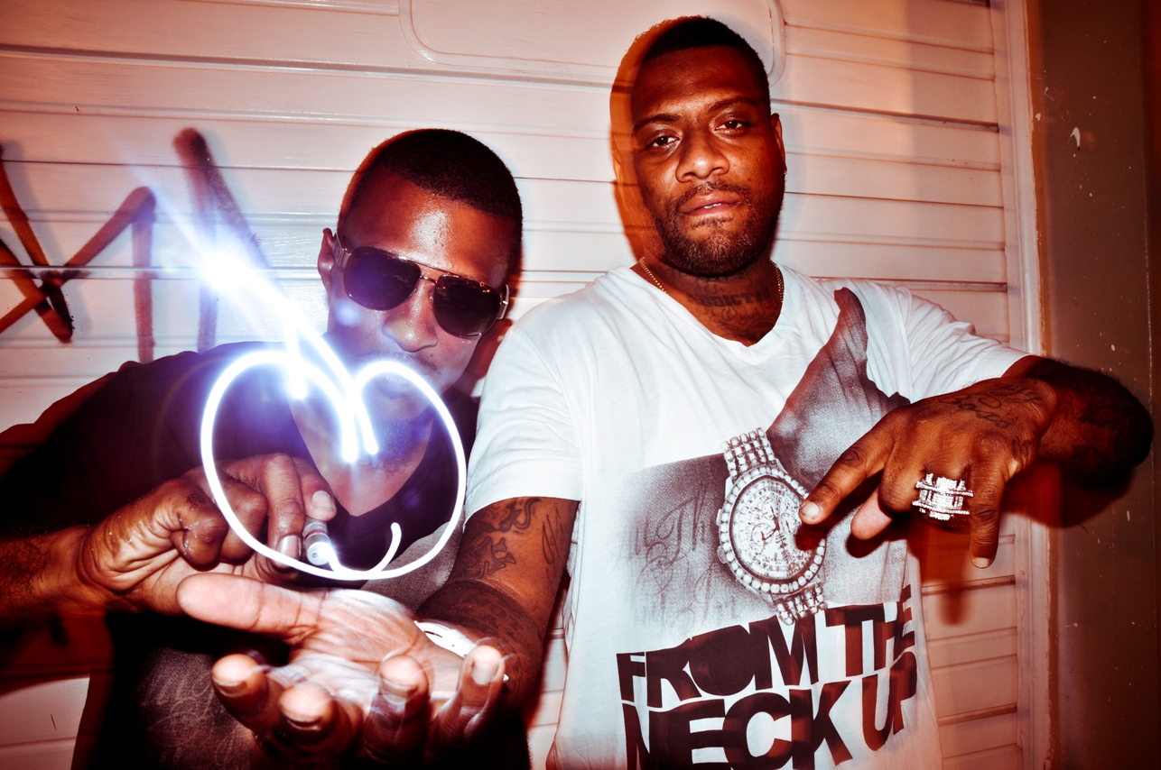 two men holding a light up hand next to each other