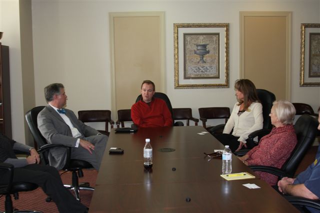 four people sitting around a conference table together