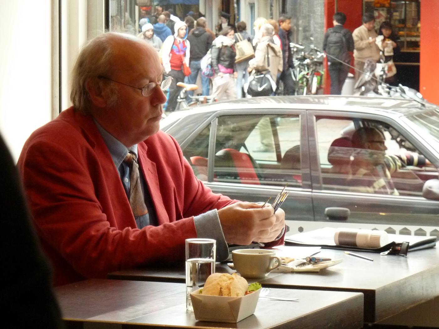 a man sitting at a table with a pen and paper in his hand